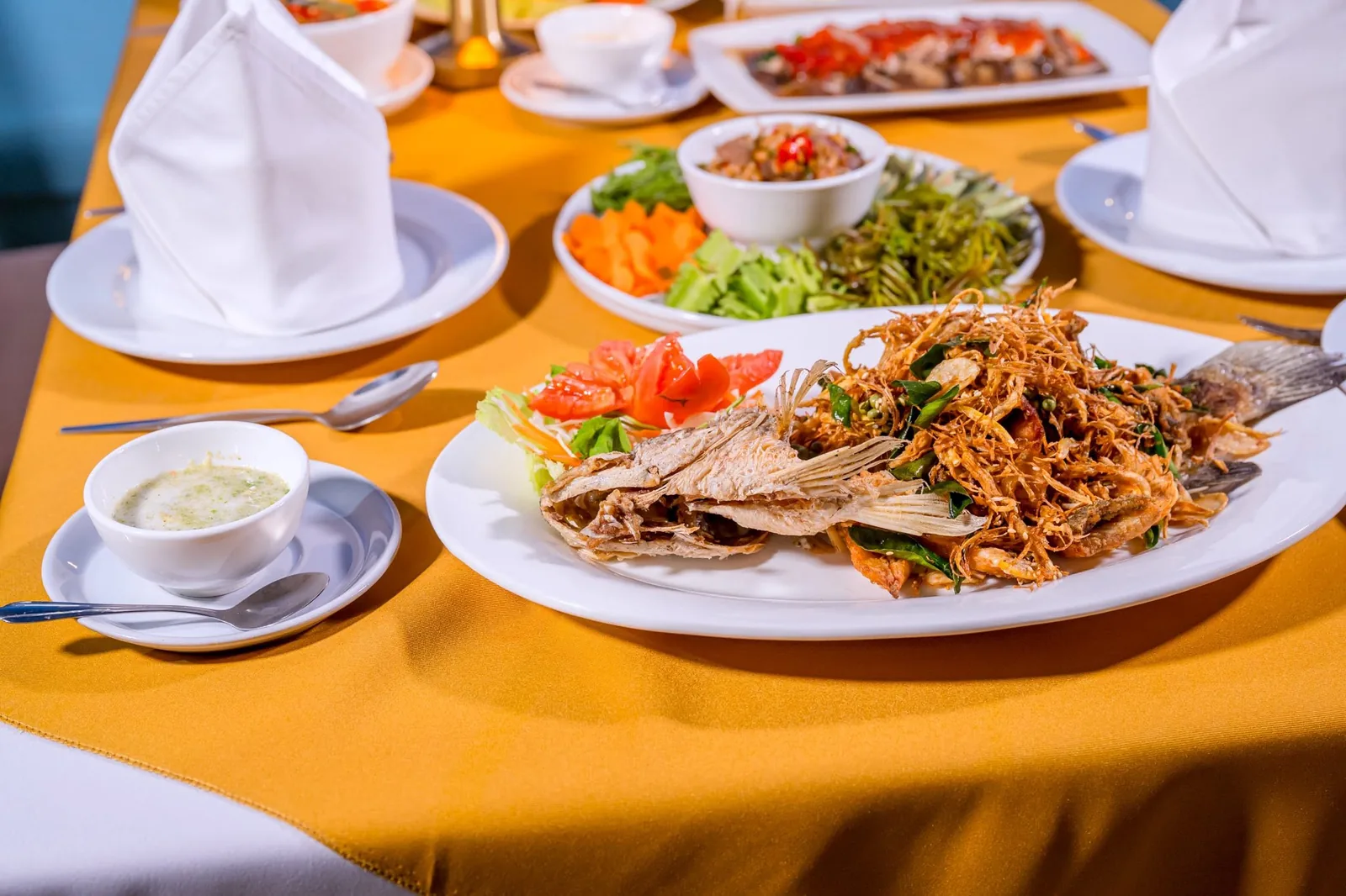 A whole fried river fish, topped with crispy herbs
