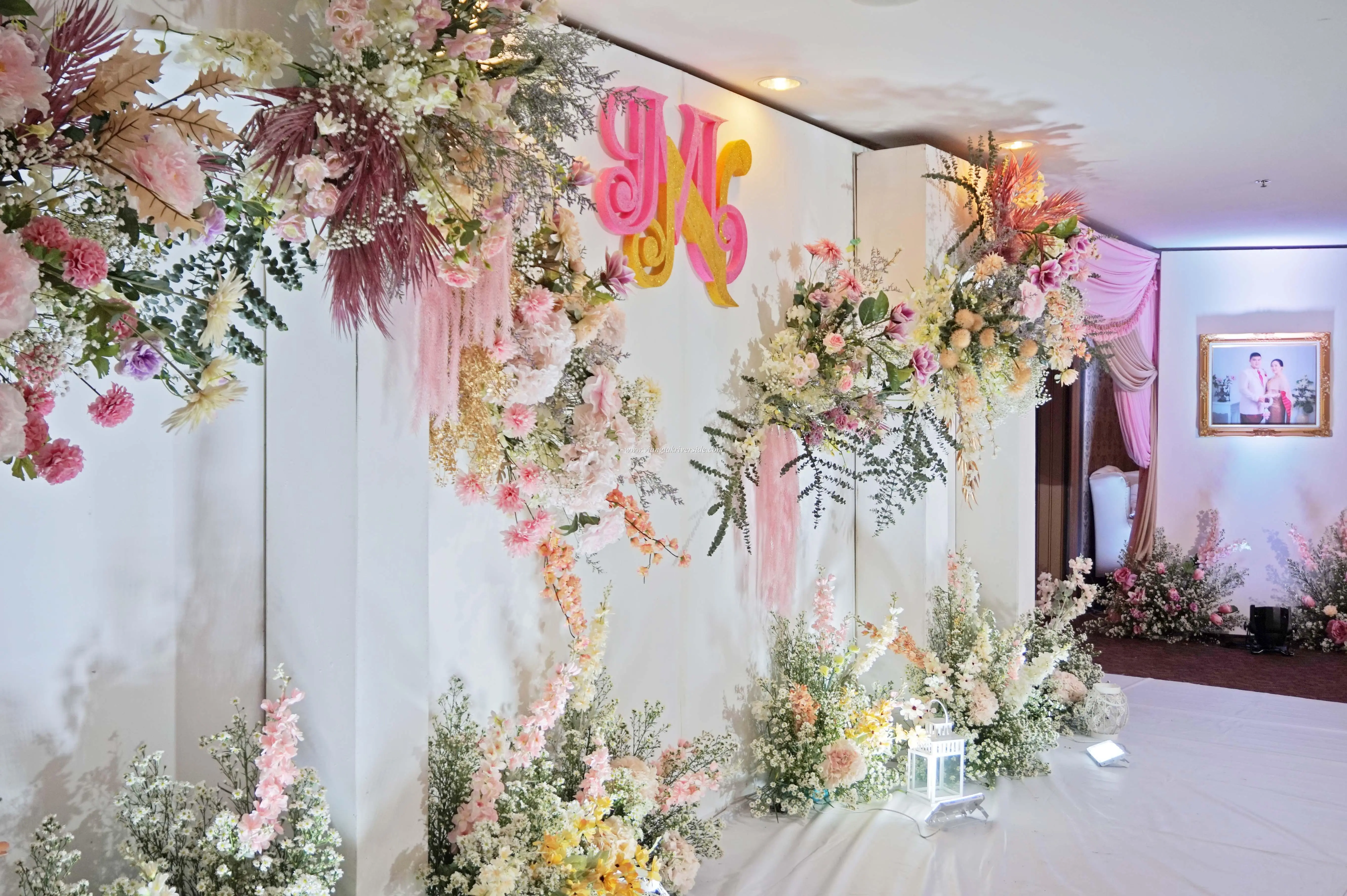 A stage background with white and pink floral decorations