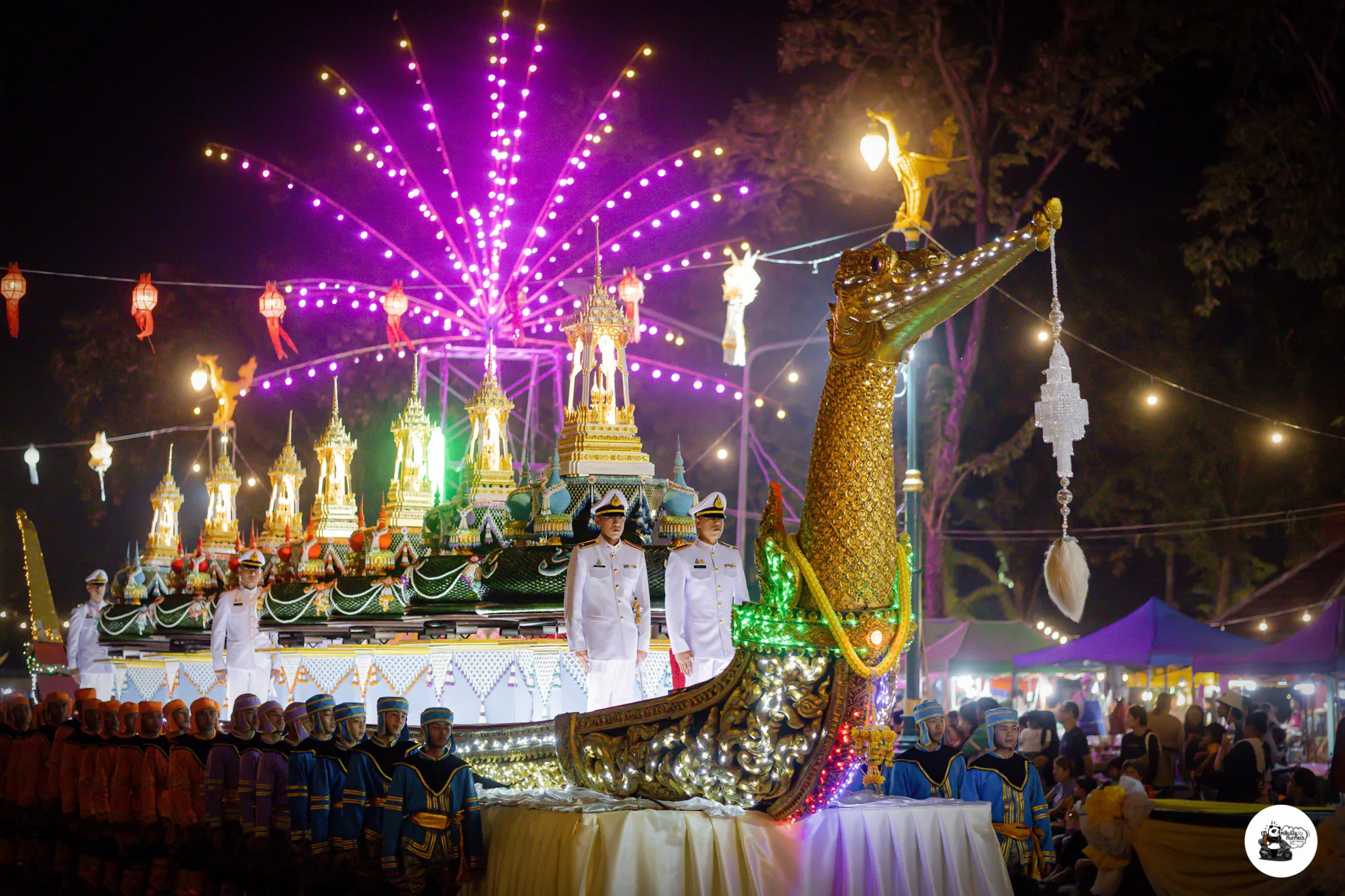 A golden ceremonial barge float carrying uniformed officers, with fireworks overhead