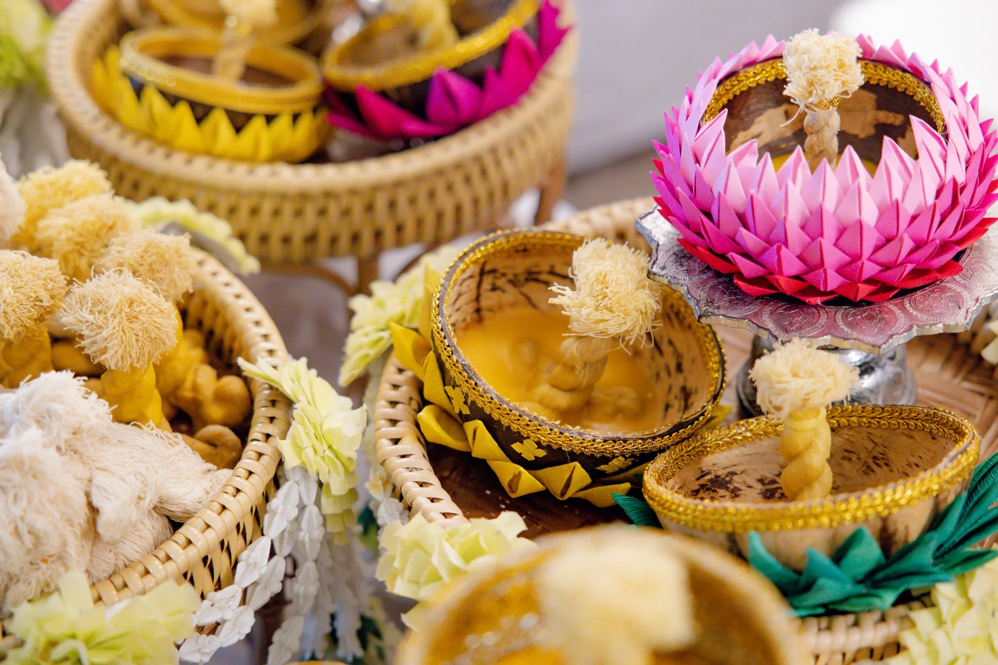 Close-up of candle wax and a cotton wick inside a coconut-shell krathong